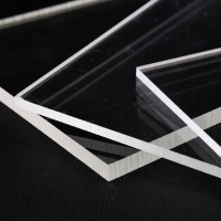 透明鑄造壓克力板堆放在黑色表面上。